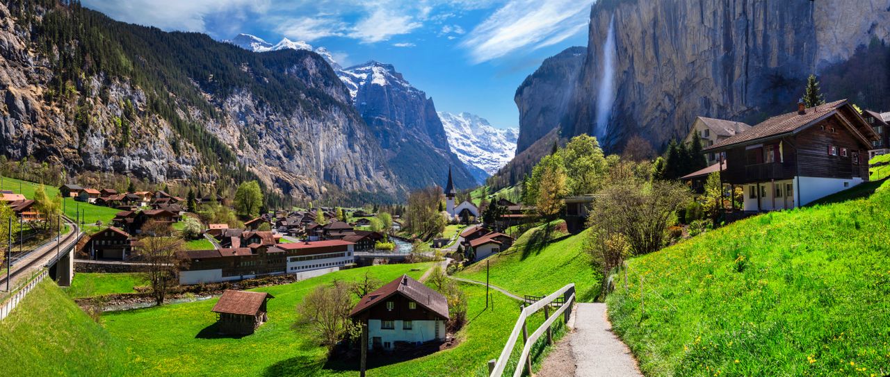 Ein idyllisches Dorf umring von hohen Bergen in der Schweiz