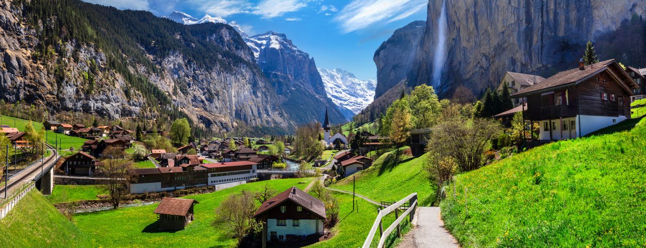 Ein idyllisches Dorf umring von hohen Bergen in der Schweiz