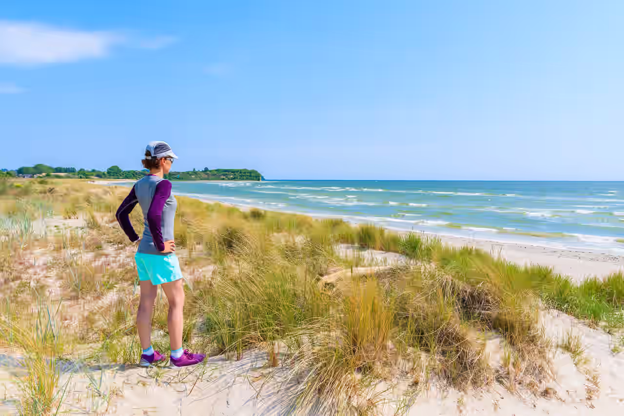 Sportlich gekleidete Frau am Strand der Ostsee in Mecklenburg-Vorpommern