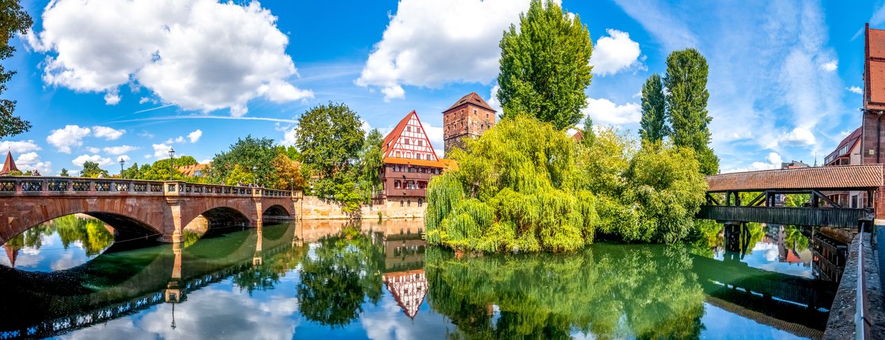 Traumhafte Landschaft in Franken mit einem Fachwerkhaus vor einem Gewässer beim Bio Urlaub in Franken erleben