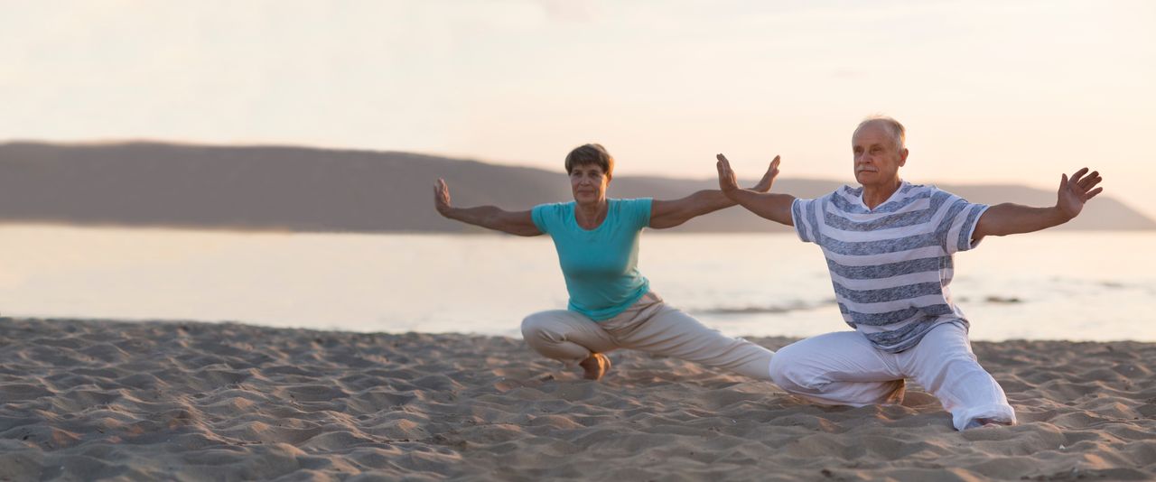 Ein älteres Paar beim Qi Gong am Strand