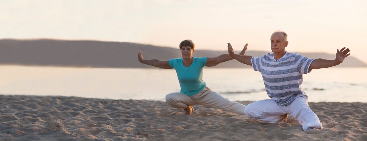 Ein älteres Paar beim Qi Gong am Strand