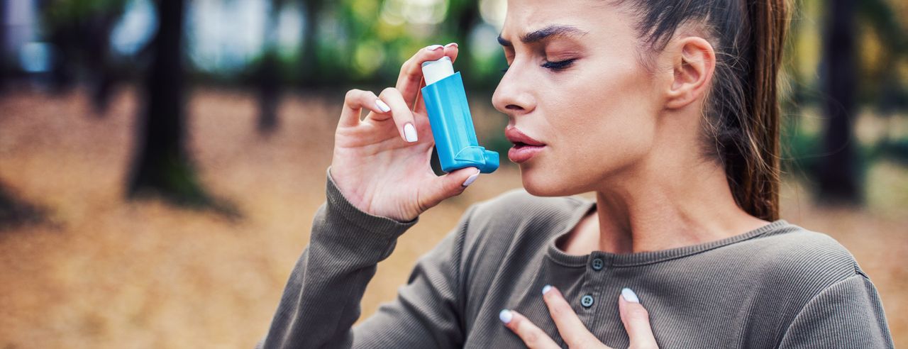 A woman uses an inhaler