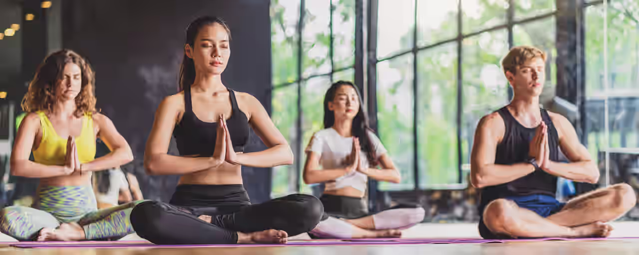Yoga-Kursteilnehmende machen den Namaste-Gruß