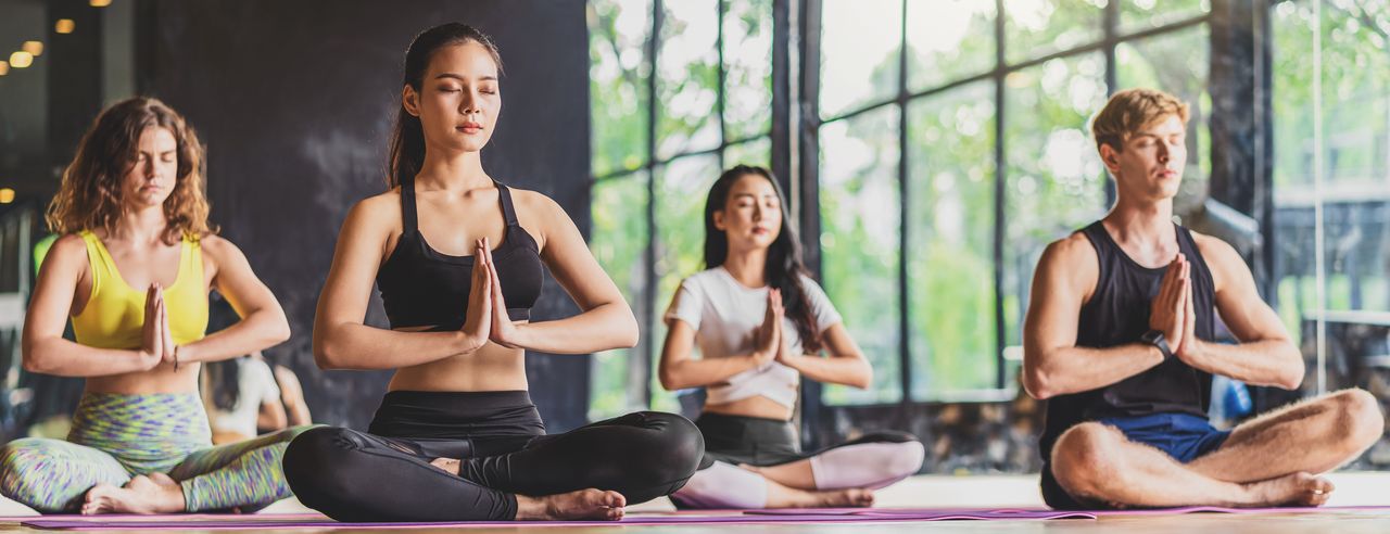 Yoga-Kursteilnehmende machen den Namaste-Gruß