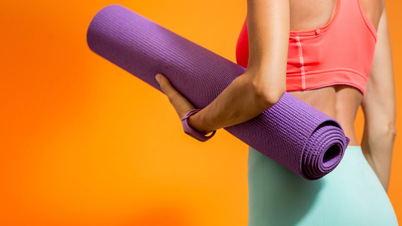 Eine Frau mit Ihrer Yogamatte im Arm ist bereit für Faszien Yoga