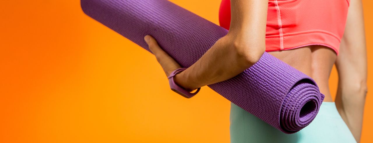 Eine Frau mit Ihrer Yogamatte im Arm ist bereit für Faszien Yoga