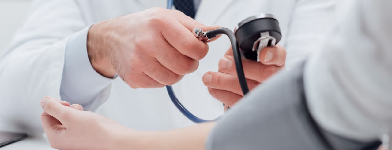 Arzt misst Blutdruck bei einem Patienten
