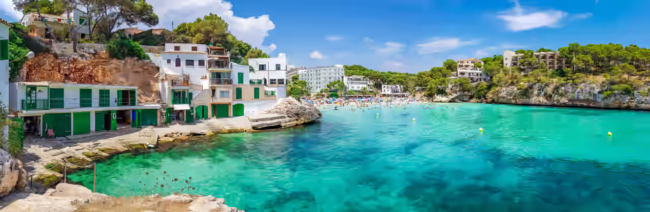 Blick auf eine Bucht auf Mallorca mit türkisblauem Wasser und Sandstrand