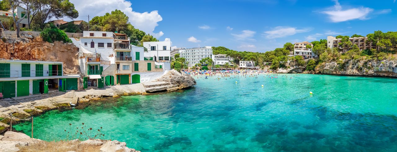 Blick auf eine Bucht auf Mallorca mit türkisblauem Wasser und Sandstrand