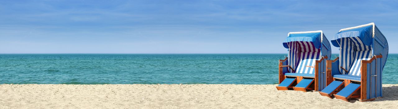 Strandpanorama mit zwei blauweißen Strandkörben