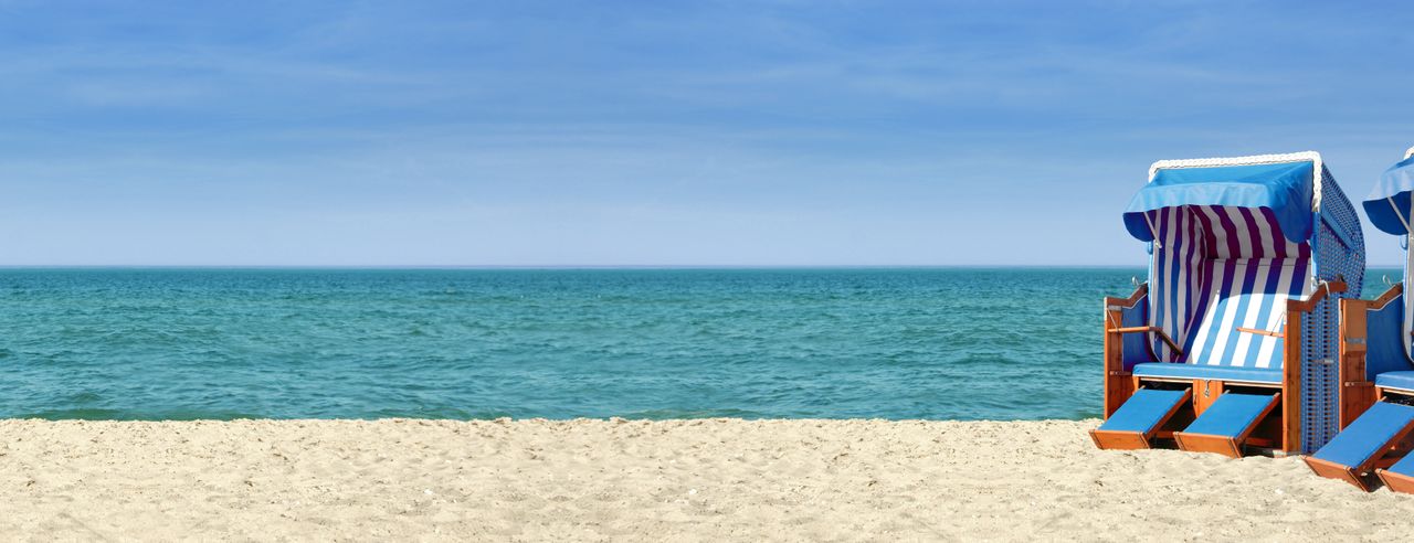 Strandpanorama mit zwei blauweißen Strandkörben