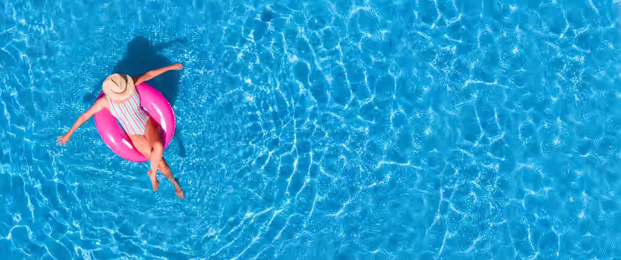 Eine Frau lässt sich entspannt im Luftring im Pool treiben in Ihrer Unterkunft mit Pool