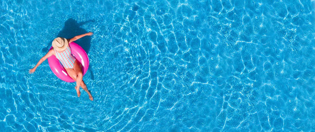 Eine Frau lässt sich entspannt im Luftring im Pool treiben in Ihrer Unterkunft mit Pool