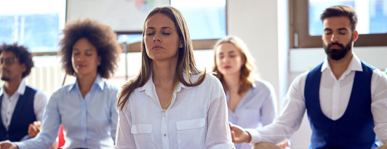 Menschen in Arbeitskleidung am meditieren