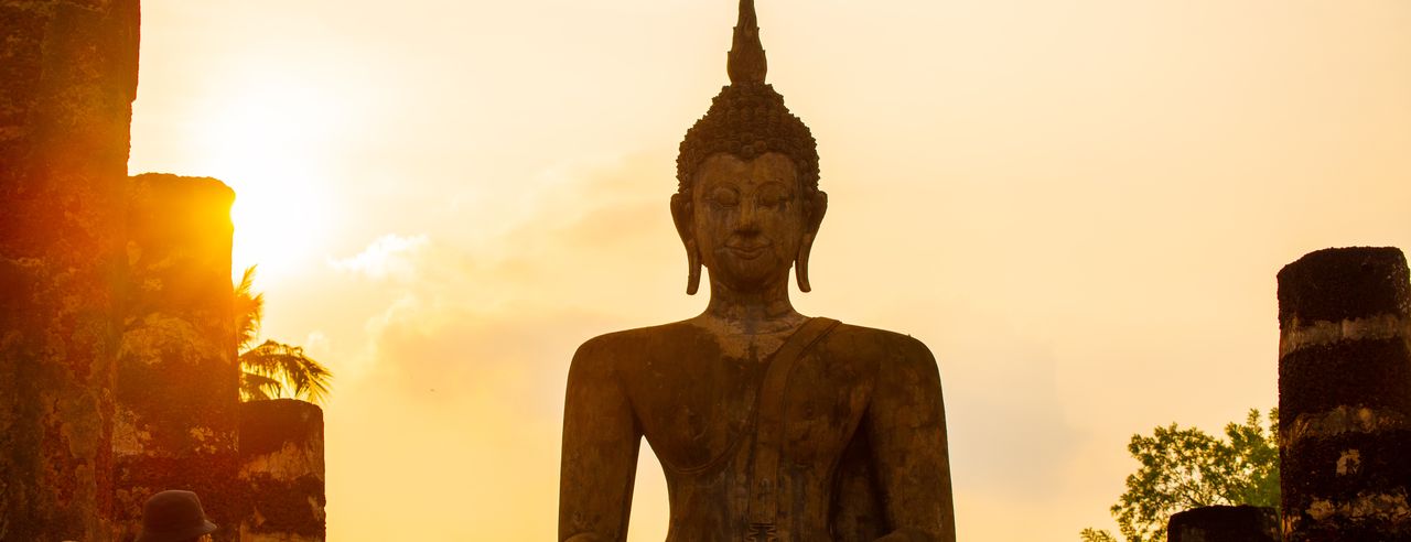 Eine große Buddah Statue vor einem Sonnenuntergang