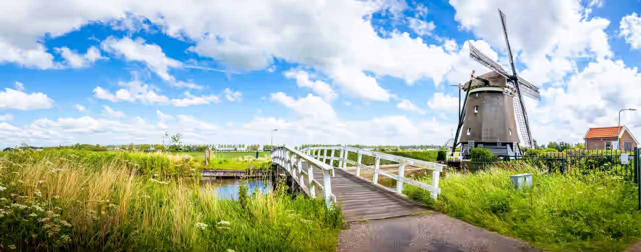 Eine Windmühle über einen Kanal in den Niederlanden bei einem Kurzurlaub entdecken
