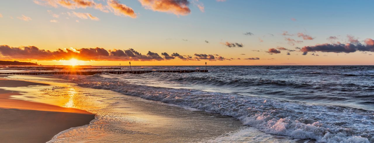 The sea with waves and a sunset in the background.